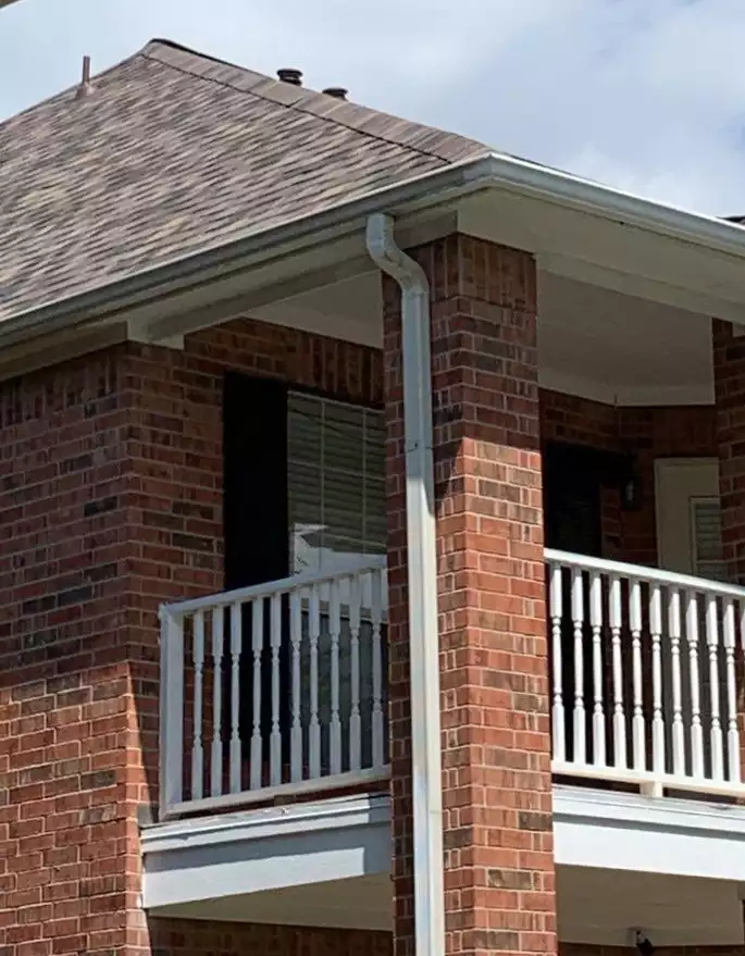 New seamless aluminum gutter and downspout installed along the edge of a Texas home