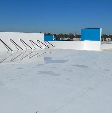 Standing seam metal roof beside an asphalt shingle roof on Texas homes under bright sun