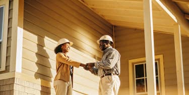 Texas homeowner reviewing paperwork with a roofing contractor outside a home