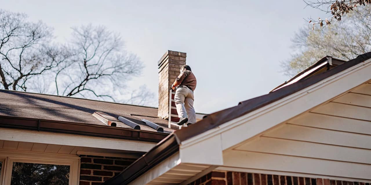 Professional roofer inspecting metal roof flashing on a residential Texas home with chimney