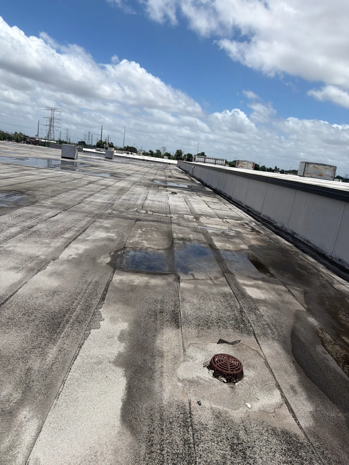 Commercial flat roof membrane installation reflecting heat on a Houston business